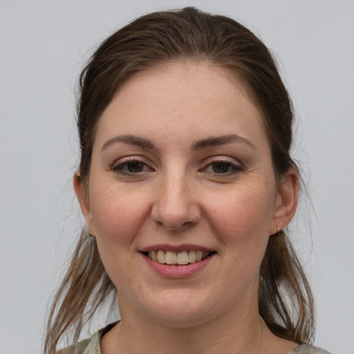 Joyful white young-adult female with medium  brown hair and grey eyes