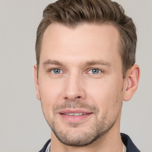 Joyful white young-adult male with short  brown hair and grey eyes