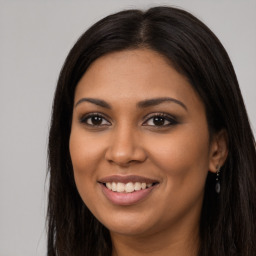 Joyful latino young-adult female with long  brown hair and brown eyes