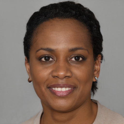 Joyful black young-adult female with short  black hair and brown eyes