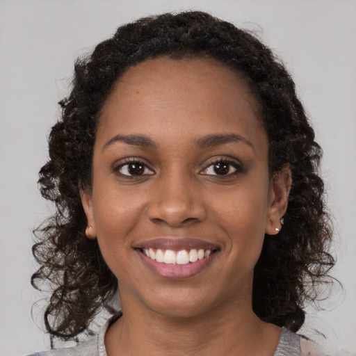 Joyful black young-adult female with medium  brown hair and brown eyes