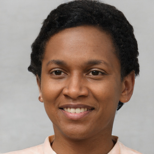 Joyful black young-adult female with short  black hair and brown eyes