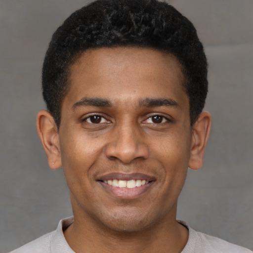 Joyful latino young-adult male with short  brown hair and brown eyes