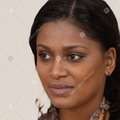 Joyful black young-adult female with long  brown hair and brown eyes