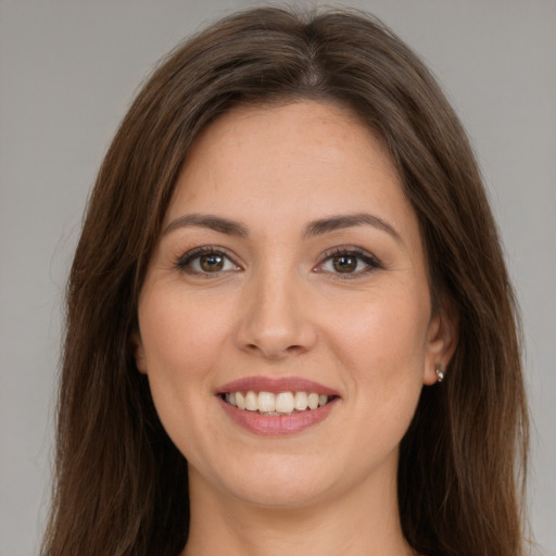 Joyful white young-adult female with long  brown hair and brown eyes