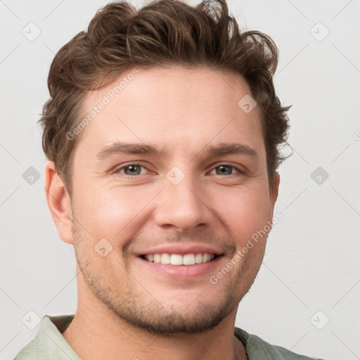 Joyful white young-adult male with short  brown hair and grey eyes