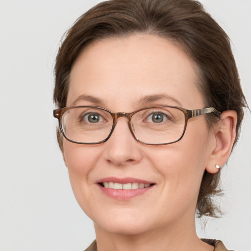 Joyful white adult female with medium  brown hair and grey eyes