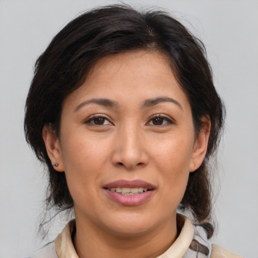 Joyful asian adult female with medium  brown hair and brown eyes