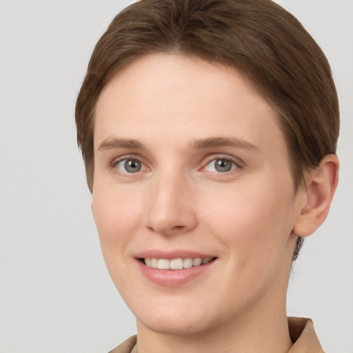 Joyful white young-adult female with short  brown hair and grey eyes