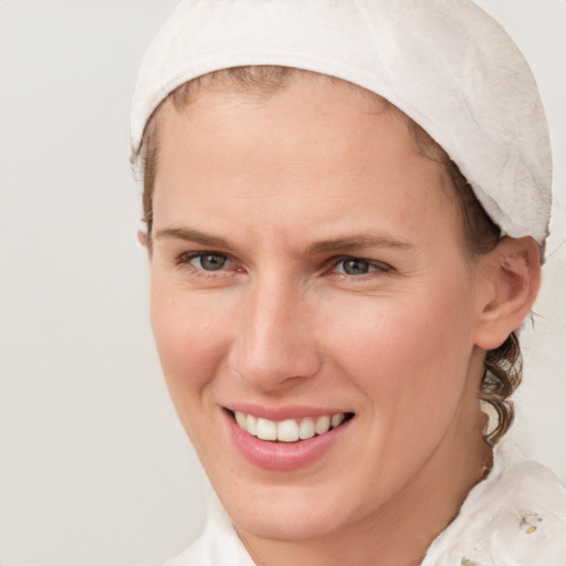 Joyful white young-adult female with short  brown hair and blue eyes