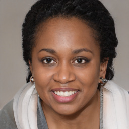 Joyful black young-adult female with long  brown hair and brown eyes