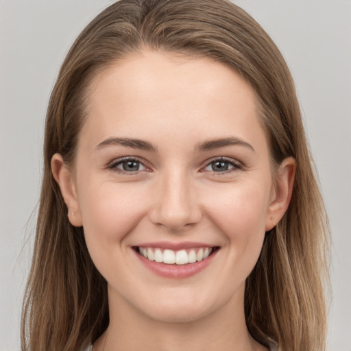 Joyful white young-adult female with long  brown hair and grey eyes