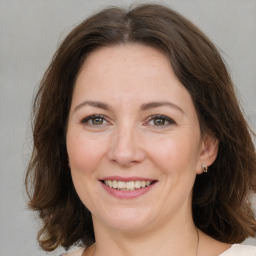 Joyful white adult female with medium  brown hair and brown eyes