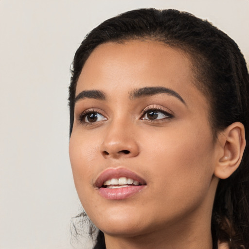 Joyful latino young-adult female with long  black hair and brown eyes