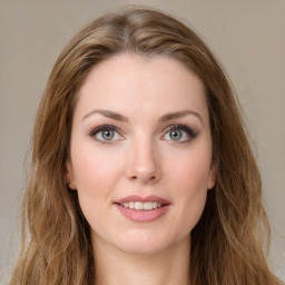 Joyful white young-adult female with long  brown hair and green eyes