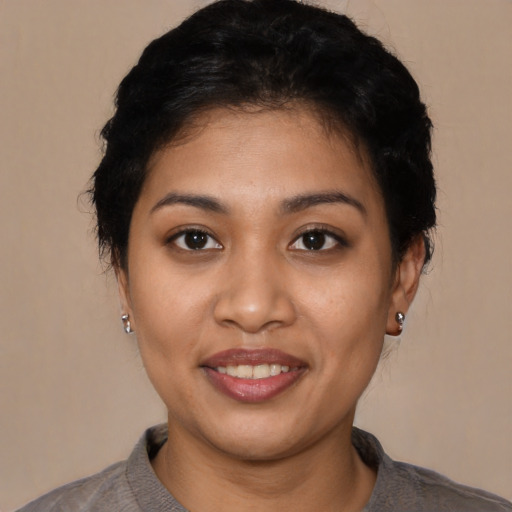 Joyful latino young-adult female with short  black hair and brown eyes