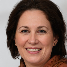 Joyful white adult female with medium  brown hair and grey eyes