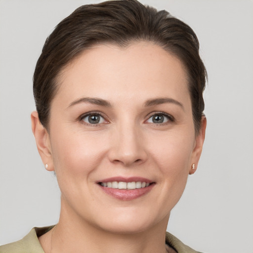 Joyful white young-adult female with short  brown hair and grey eyes