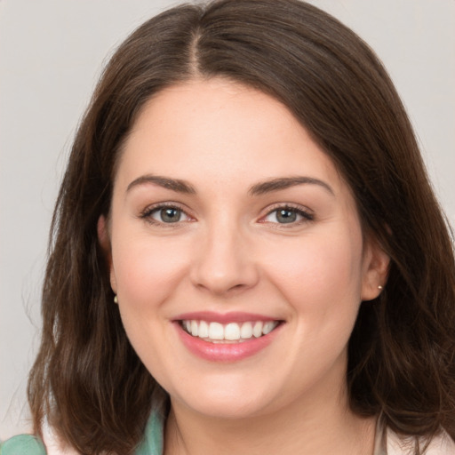 Joyful white young-adult female with medium  brown hair and green eyes