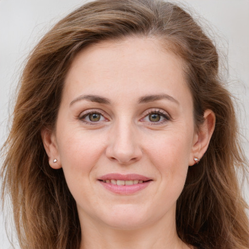 Joyful white young-adult female with long  brown hair and green eyes