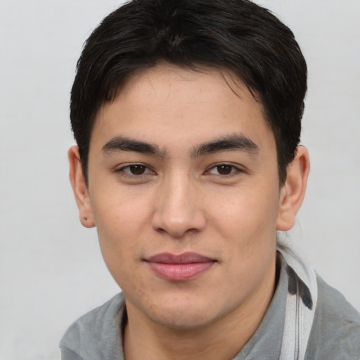 Joyful asian young-adult male with short  brown hair and brown eyes