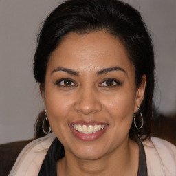 Joyful latino young-adult female with medium  brown hair and brown eyes