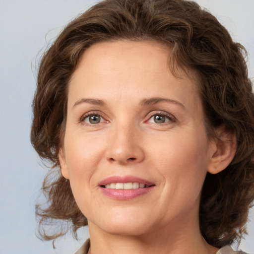 Joyful white young-adult female with medium  brown hair and green eyes