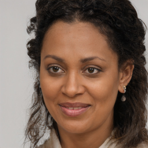 Joyful black young-adult female with long  brown hair and brown eyes