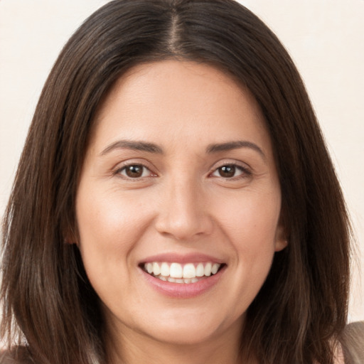 Joyful white young-adult female with long  brown hair and brown eyes