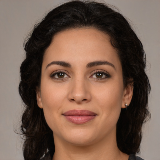 Joyful latino young-adult female with medium  brown hair and brown eyes