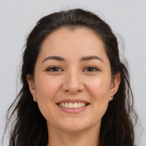 Joyful white young-adult female with long  brown hair and brown eyes