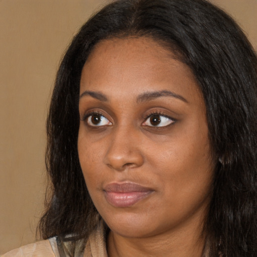 Joyful black young-adult female with long  black hair and brown eyes