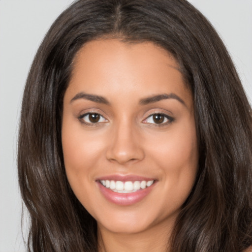 Joyful latino young-adult female with long  brown hair and brown eyes