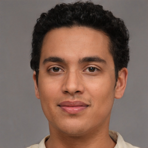 Joyful latino young-adult male with short  brown hair and brown eyes