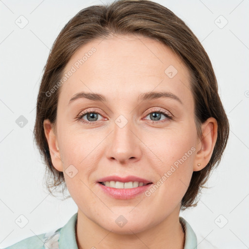 Joyful white young-adult female with medium  brown hair and grey eyes