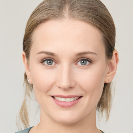 Joyful white young-adult female with medium  brown hair and grey eyes