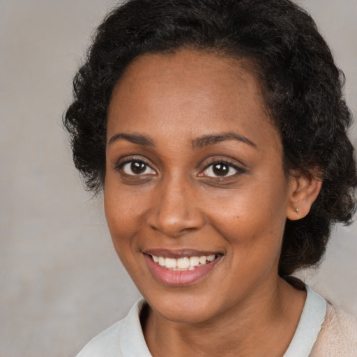 Joyful black young-adult female with medium  brown hair and brown eyes