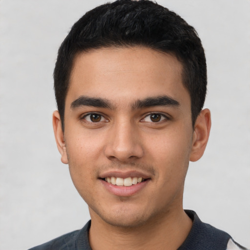 Joyful latino young-adult male with short  black hair and brown eyes