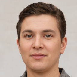 Joyful white young-adult male with short  brown hair and grey eyes