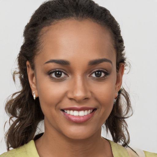 Joyful black young-adult female with medium  brown hair and brown eyes