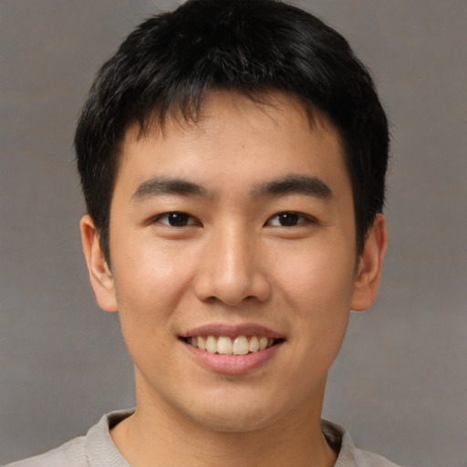 Joyful asian young-adult male with short  brown hair and brown eyes