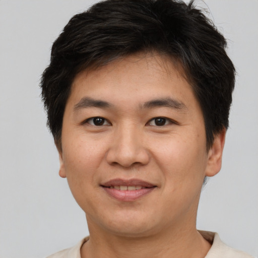 Joyful asian young-adult male with short  brown hair and brown eyes