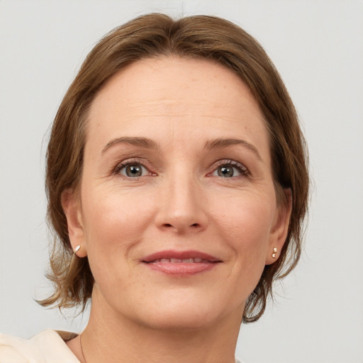 Joyful white adult female with medium  brown hair and grey eyes