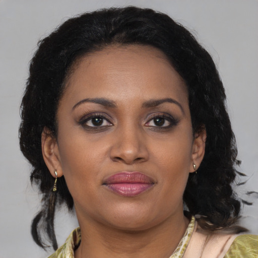 Joyful black adult female with medium  brown hair and brown eyes