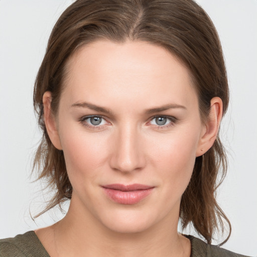 Joyful white young-adult female with medium  brown hair and grey eyes