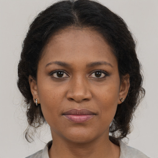 Joyful black young-adult female with medium  brown hair and brown eyes
