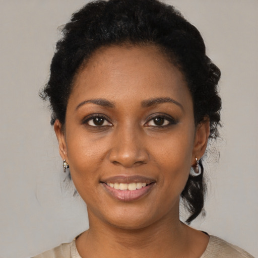 Joyful black young-adult female with short  black hair and brown eyes