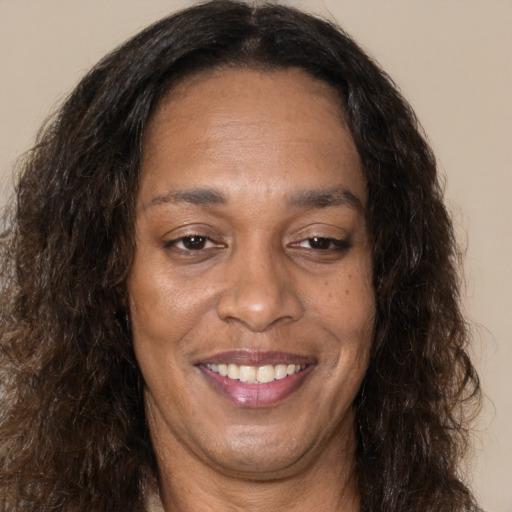 Joyful black adult female with long  brown hair and brown eyes
