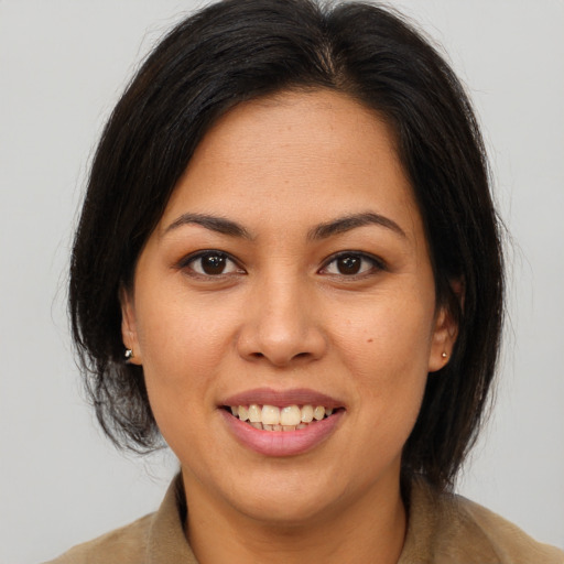 Joyful latino young-adult female with medium  brown hair and brown eyes