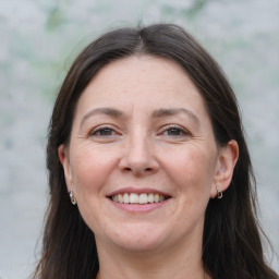 Joyful white adult female with long  brown hair and brown eyes